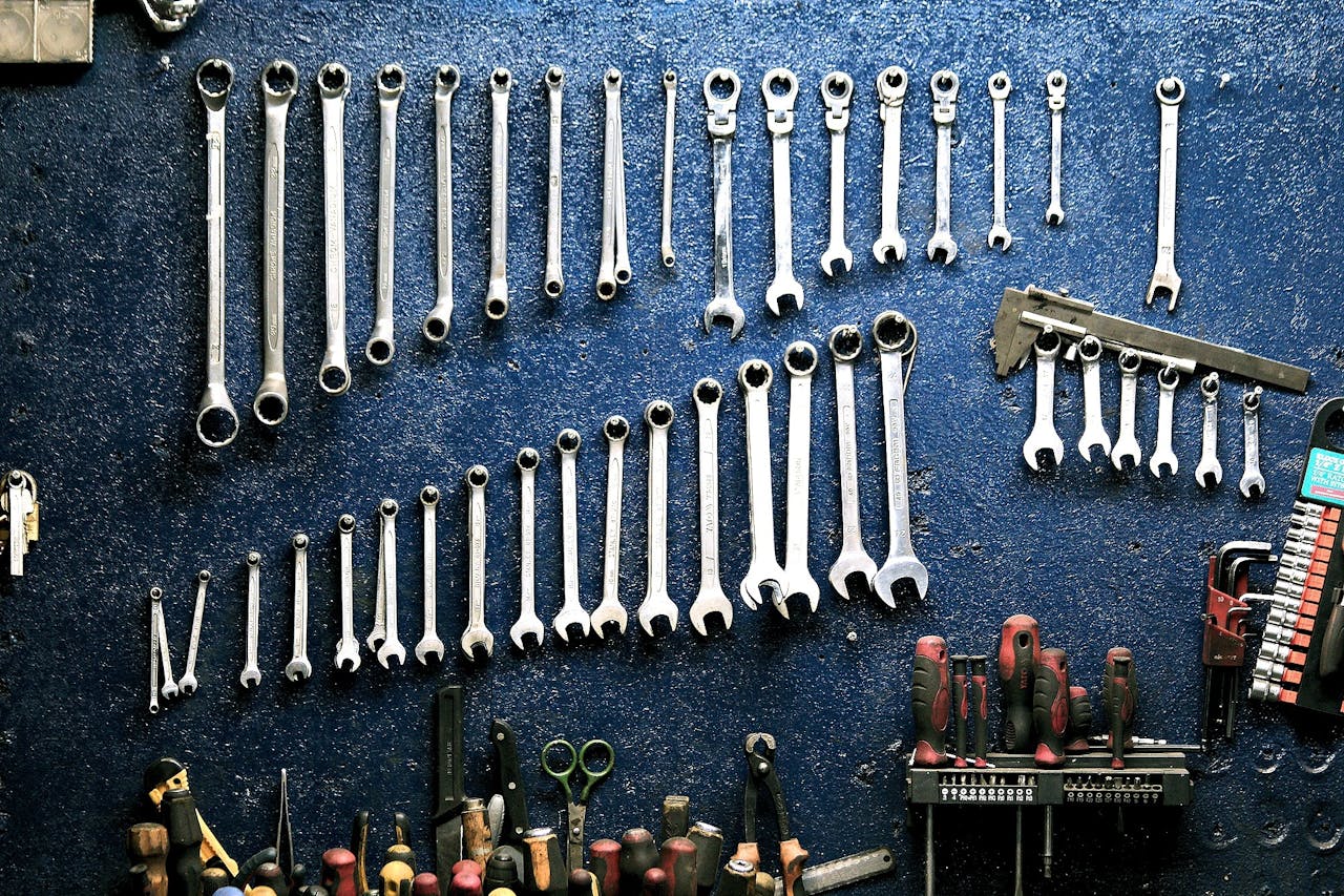 services-03 Neatly arranged wrenches and tools on a workshop wall, ideal for mechanics.