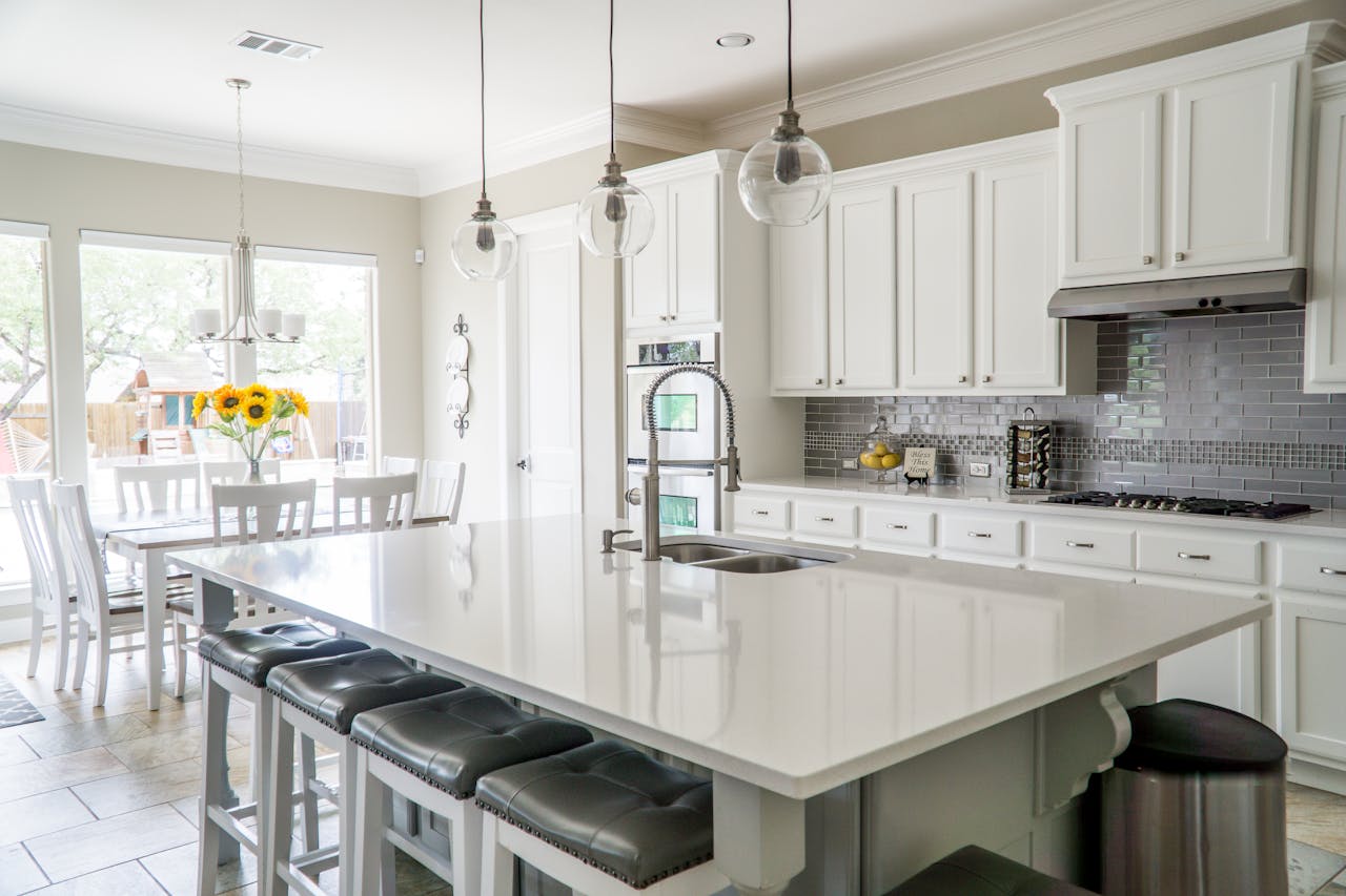gallery-1 Spacious modern kitchen with white cabinets and island in natural light.