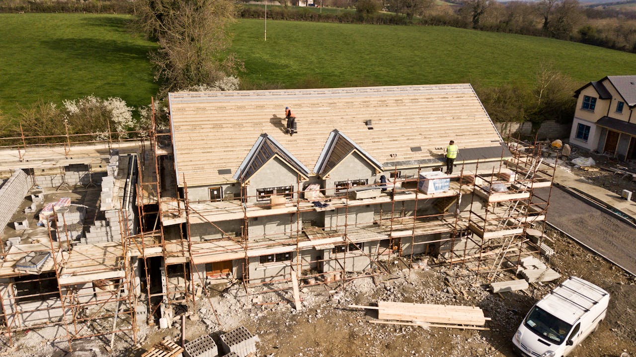 about-01 Aerial shot of a house under construction in Clonmel, Ireland. Workers on the roof.