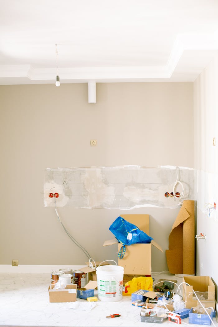 gallery-2 An indoor scene showing a messy home renovation project with tools, paint, and materials scattered around.