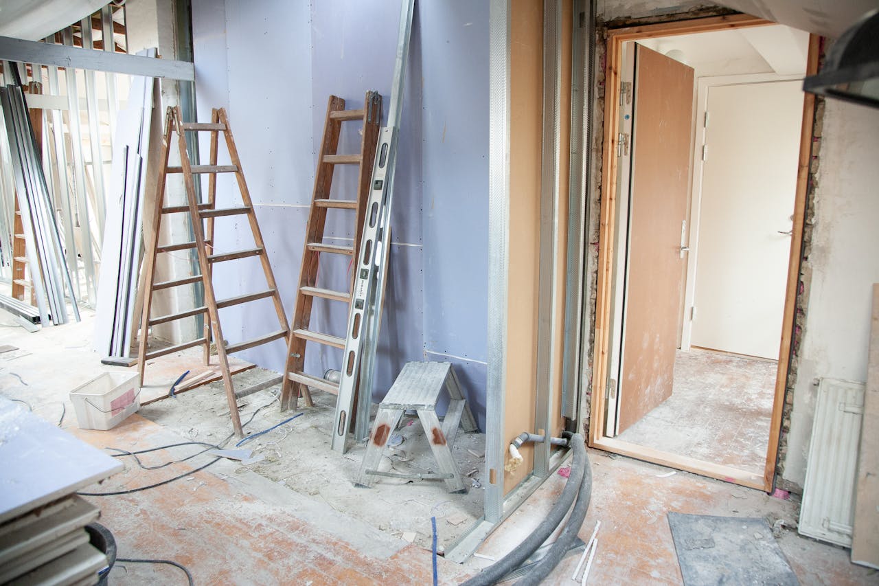 hero-img-02 Construction site featuring ladders and tools in a home renovation setting.