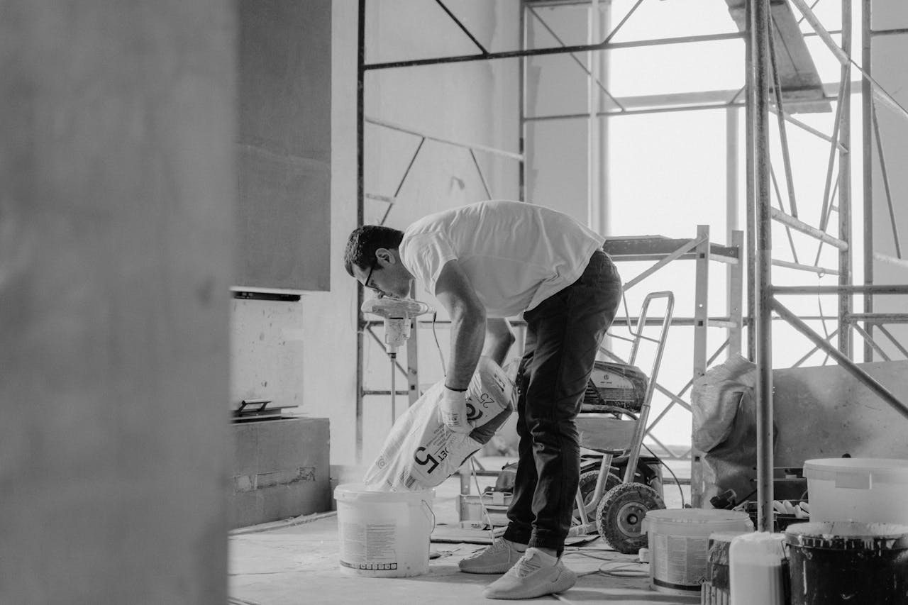 services-02 A construction worker pours materials inside a building under renovation.